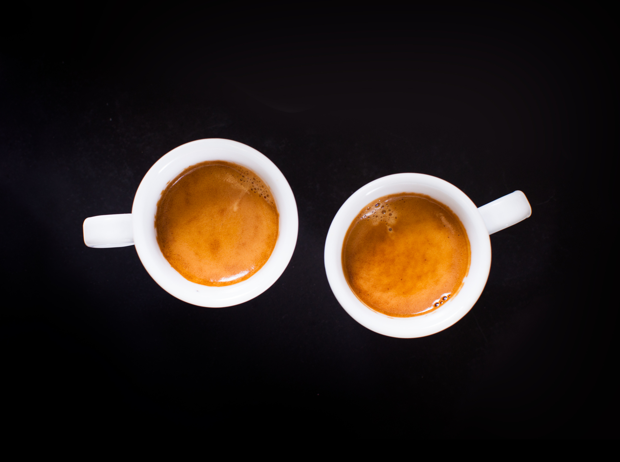 Two white cups of espresso